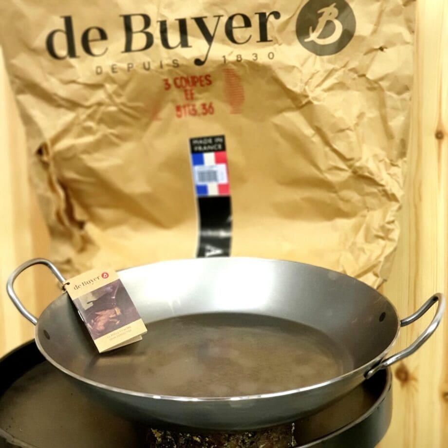 Paellapanna 36 cm de Buyer Detta är en rejäl Paellapanna i storleken 36cm i diameter. För paella eller som en stekpanna som passar i klotgrillen eller Kamadon. Tack vare just kolstål sprider sig värmen jämnt över hela den gigantiska ytan. Med öronen är denna panna 47 cm i diameter vilket gör att den passar i de flesta klotgrillar och Kamados. Franska de Buyer är kända för sina proffsiga köksprodukter och då främst deras grymma pannor i kolstål. Många uppskattar kolstålens egenskaper framför gjutjärn: lättare, snabbare att varma upp och ett material gjort för att kunna hantera riktigt höga temperaturer. Passar lika bra oavsett om du har en kolgrill, gasgrill, gasspis, induktionshäll eller en klassisk spisplatta i järn. Ytan kommer med tiden att bli svart och non-stick så länge du har lite tålamod med instekningen och enbart diskar den med hett vatten. Materialet är mycket grovt och det skall mycket till för att pannan skall slå sig. Förutom att det är en fantastisk panna att steka i så går den även utmärkt att använda som ett exklusivt och annorlunda serveringsfat - rustikt är bara förnamnet! Kolstål blir bara snyggare och bättre med tiden - en riktigt tung dukning som lyfter vilka rätter som helst. Mått: 36 cm diameter två handtag för möjlighet till tvåhandsgrepp. robust rustik design snabbuppvärmd fritt från gifter och plaster